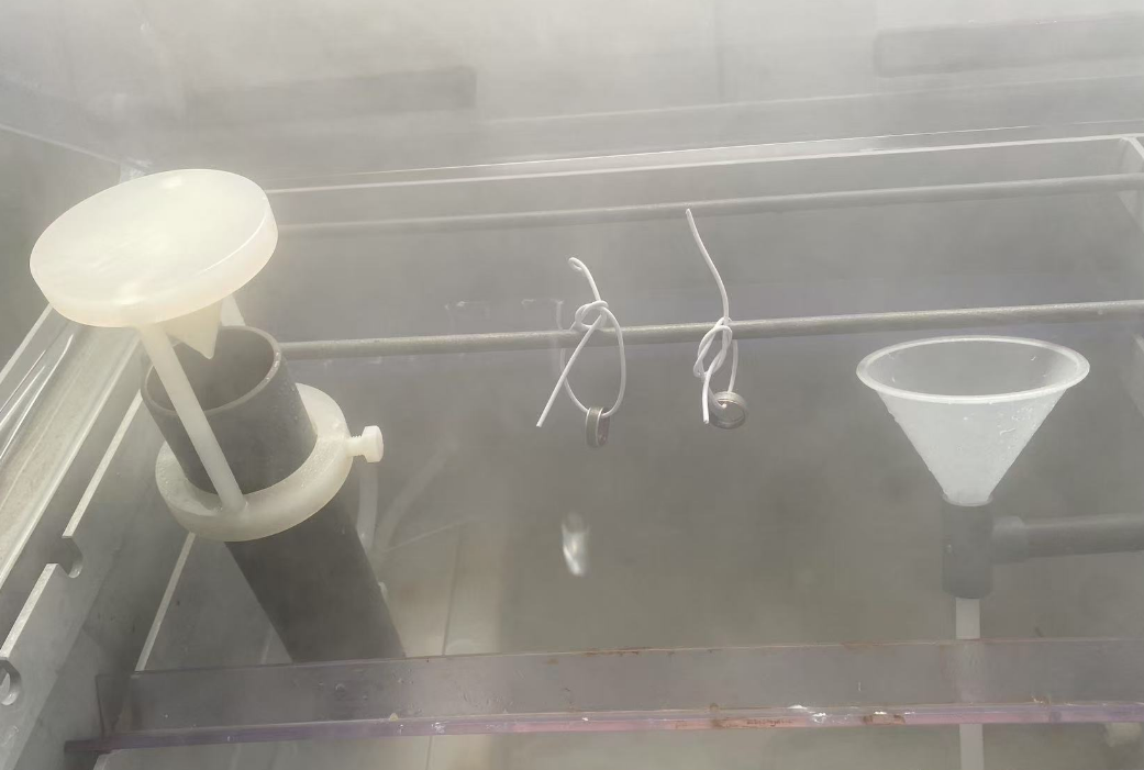 Humidity exposure test setup with rings suspended inside chamber